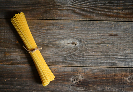 Bunch of spaghetti on wooden table background with copy spaceの写真素材