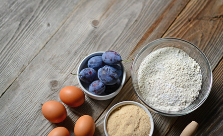 Baking plum cake on wooden tableの写真素材