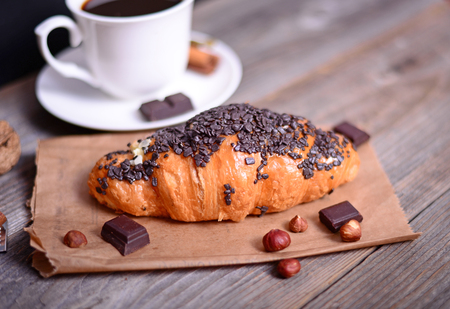 Chocolate croissant with coffee on wooden backgroundの写真素材