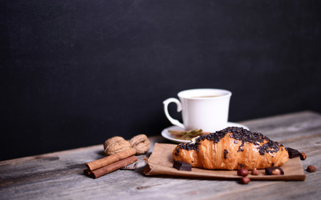 Chocolate croissant with coffee on wooden backgroundの写真素材