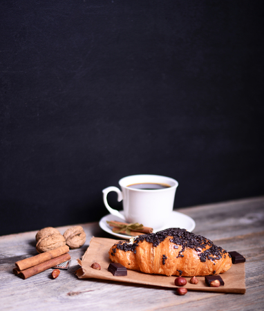Chocolate croissant with coffee on rustic tableの写真素材