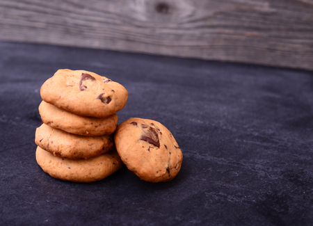 Chocolate cookies on black table. Stacked chocolate chip cookies close up.の写真素材