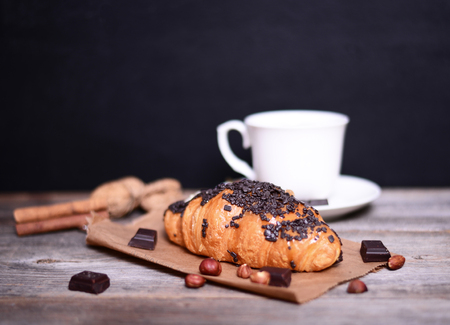 Chocolate croissant and coffee on wooden tableの写真素材