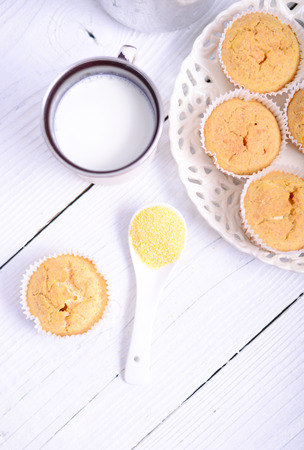 Cornbread muffins and milk on white tableの写真素材