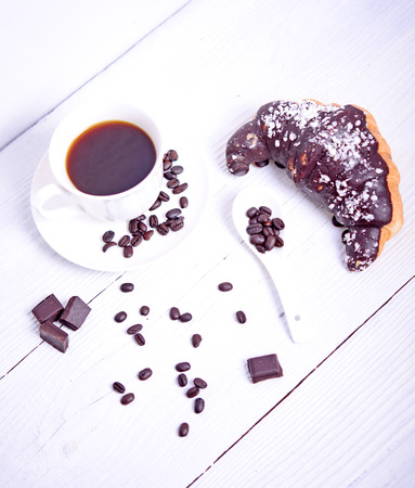 Fresh chocolate croissant with coffee and chocolate on white backgroundの写真素材