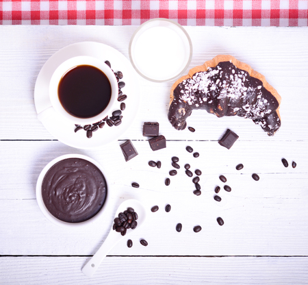 Fresh chocolate croissant with coffee and chocolate on white backgroundの写真素材
