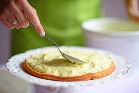 Woman hand put pudding on the cake crustの写真素材