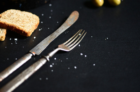 Old rustic knife and fork on black table closeupの写真素材