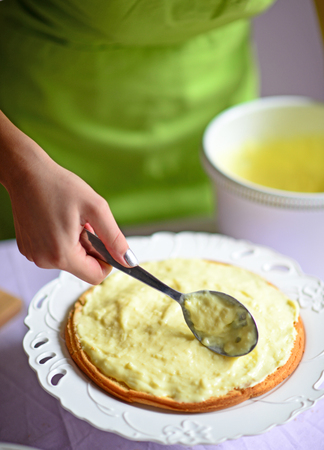 Woman hand put pudding on the cake crustの写真素材