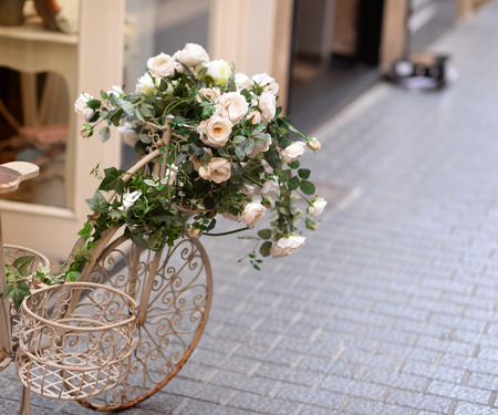 Beautiful white vintage bicycle with flowers on streetの写真素材