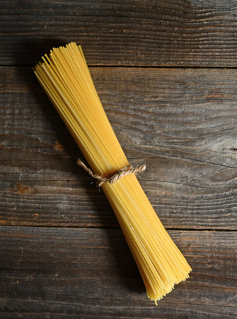 Bunch of spaghetti on wooden table background with copy spaceの写真素材