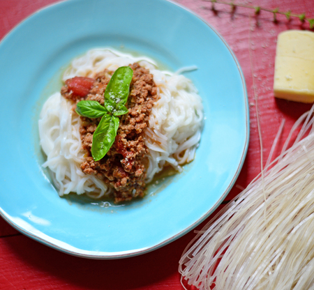Italian spaghetti on rustic wooden table with rice noodleの写真素材