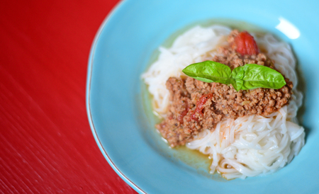 Italian spaghetti on rustic red tableの写真素材