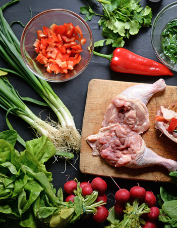 Young woman preparing chicken with vegetablesの写真素材