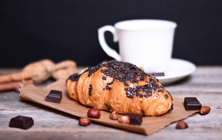 Chocolate croissant and coffee on wooden tableの写真素材