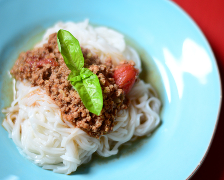 Italian spaghetti on red wooden tableの写真素材