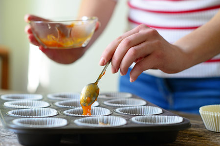 Woman hand prepare healthy muffins with jam