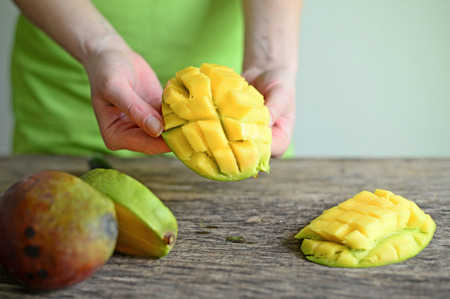 Hand Holding Fresh Mango , Cut in Square Shape Concept of Food Art, Idea of Decorated Foodの写真素材