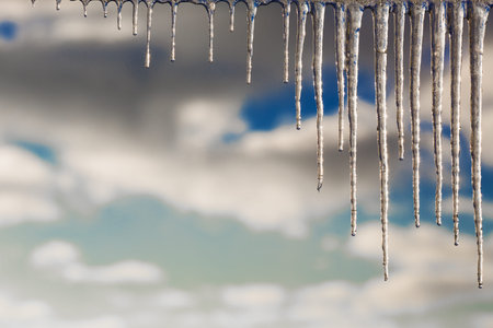 Winter icicles against the background of the cloudy skyの写真素材