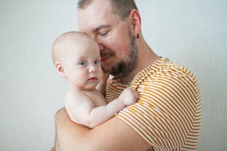 Cute baby on the arms of his big strong dad. Relations between daughters and dads. Fathers day