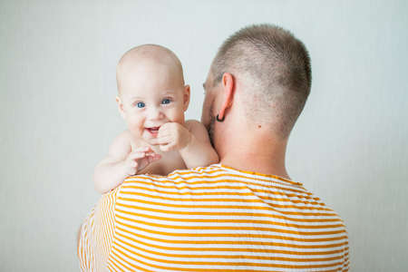 Cute baby on the arms of his big strong dad. Relations between daughters and dads. Fathers dayの写真素材