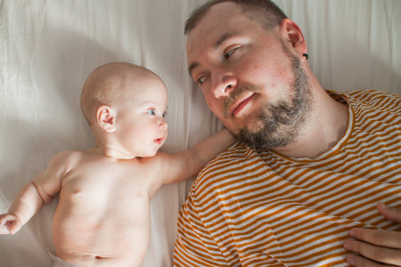 Cute baby on the arms of his big strong dad. Relations between daughters and dads. Fathers day