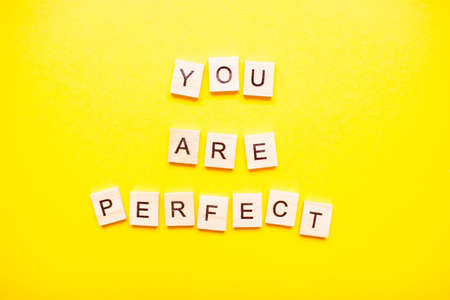 The inscription you are perfect made of wooden blocks on a light yellow background.の写真素材