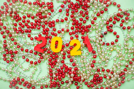 Happy New year 2021 celebration. The inscription 2021 on the background of New Years decorations: gold and red shiny beadsの写真素材
