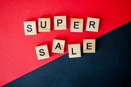 The inscription super sale from wooden blocks on a black and red backgroundの写真素材