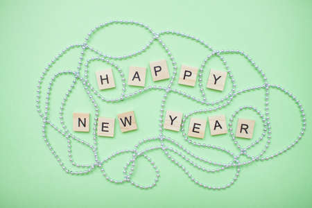 inscription happy new year in a new year frame of silver beads on a green backgroundの写真素材