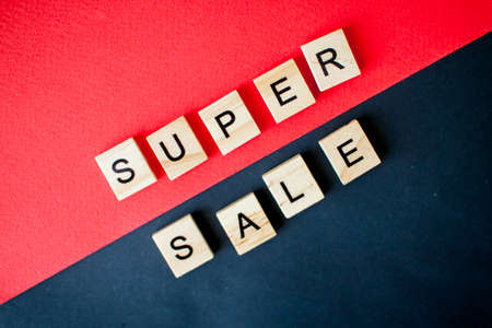 The inscription super sale from wooden blocks on a black and red backgroundの写真素材