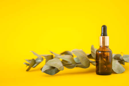Cosmetic bottles with serum on a bright yellow background. Cosmetology and beauty concept.の写真素材