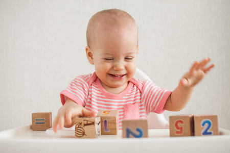 Little girl playing with wooden cubes with bright numbers. High quality photo