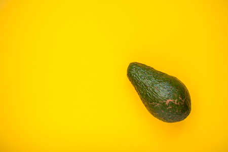 Ripe beautiful avocado on a bright yellow background. High quality photoの写真素材