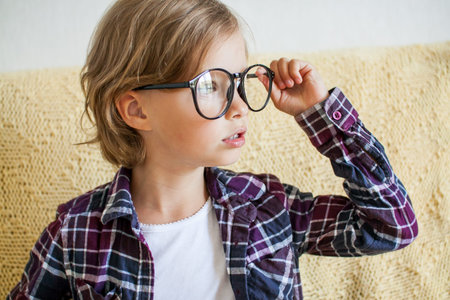 Cheerful girl in a plaid shirt and glasses. Online learning concept. High quality photo