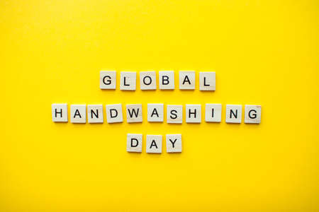 The inscription global handwashing day from wooden blocks on a bright yellow background. High quality photoの写真素材