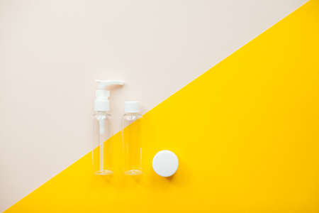 Layout on a bright yellow background. Jars for cosmetics. Travel set. High quality photoの写真素材