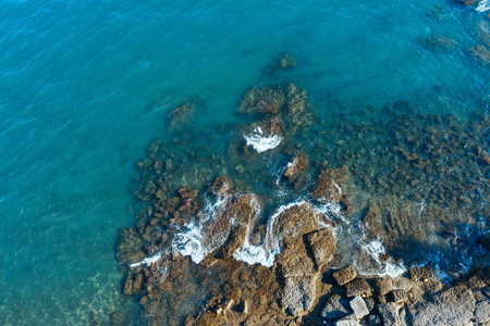 Aerial view. The waves of the Mediterranean Sea of Turkey beat on the rocks. The surf of turquoise...