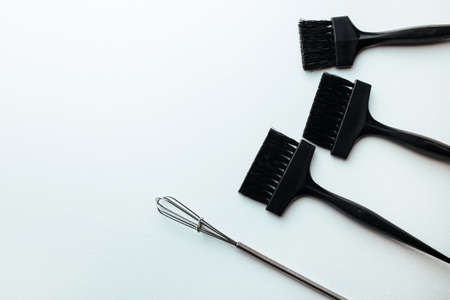 a broom and a brush for dyeing hair on a white background. hair coloring concept and parekmahep instrumentの写真素材