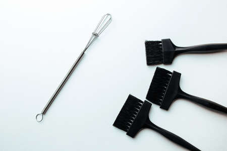 a broom and a brush for dyeing hair on a white background. hair coloring concept and parekmahep instrumentの写真素材