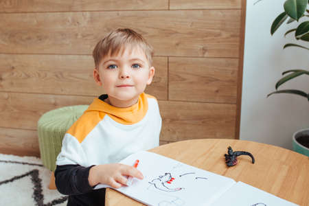 a fair-haired boy draws with a felt-tip pen. preparing for the school dayの写真素材