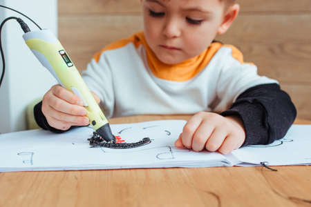 a child plays with a 3D pen. close up in the frame only the hands and the penの写真素材