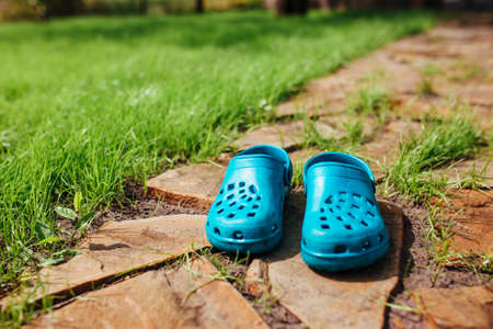 rubber sandals stand on the garden path near the lawn grassの写真素材
