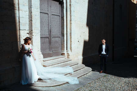 Wedding. The bride stands with a bouquet waiting for the groom. Meeting of the newlyweds at the churchの写真素材