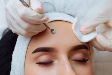 A procedure for mechanical or manual face cleansing by a beautician. Professional skin peeling. Hygiene for the skin.の写真素材