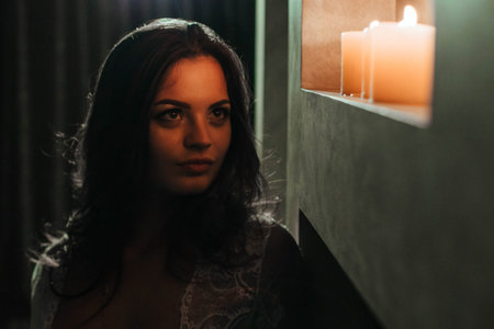 Aromatherapy. A sexy brunette in underwear extinguishes candles before bedtime. Romantic setting on Valentines Dayの写真素材