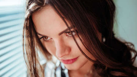 beautiful brunette woman with natural hair in sensual pose on bed with open shirt and white pantiesの写真素材