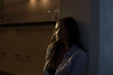 close-up Sexy girl in a mans shirt waiting for her lover sitting in the kitchenの写真素材