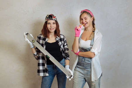 Wipes two sexy girls with a construction tool in their hands. Repair with their own hands inside the houseの写真素材