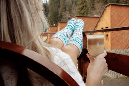 A young beautiful woman in warm handmade knitted clothes at home. . spring, winter season. Gaiters. Knee socks. Leggingsの写真素材